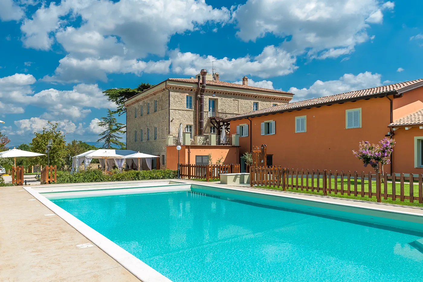 La piscina esterna con il casale sullo sfondo