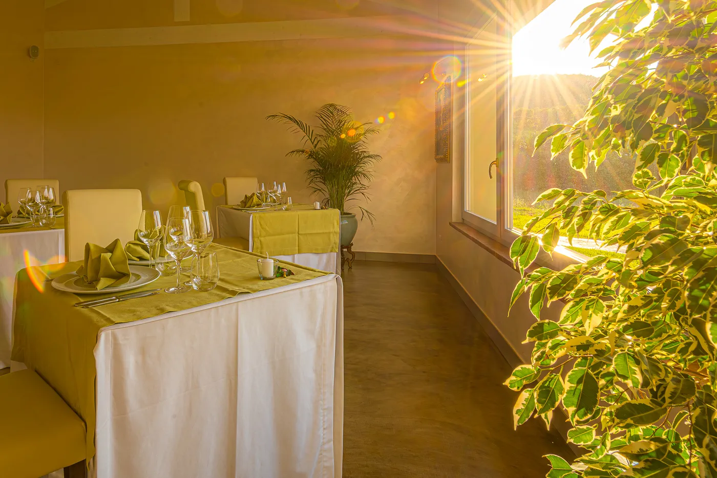 Tavolo apparecchiato in veranda, con la luce dorata del pomeriggio