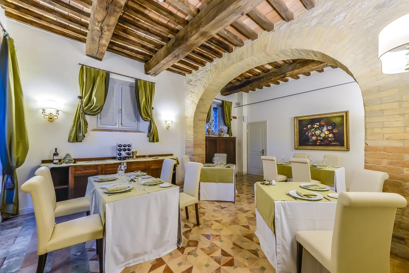 La sala ristorante apparecchiata sotto le volte del casale