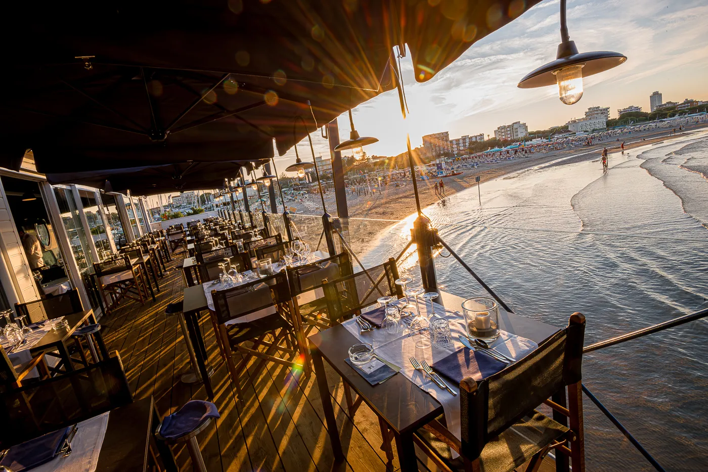 La veranda sull’acqua al tramonto, con i tavoli apparecchiati