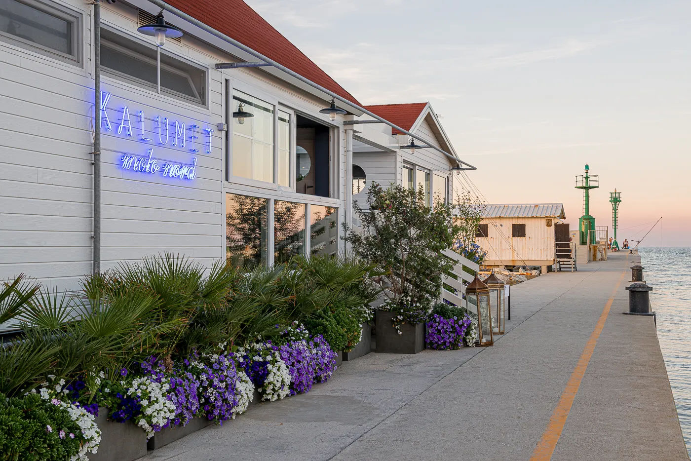 L’ingresso sul molo con l’insegna al neon e i fiori