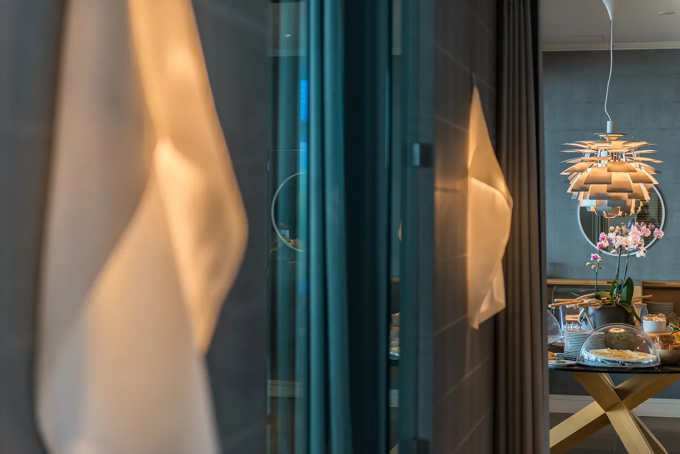 Dettaglio di design della suite, con le tende e la lampada a sospensione