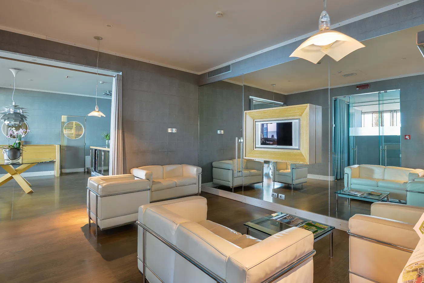 Il living di design con i divani bianchi e gli specchi