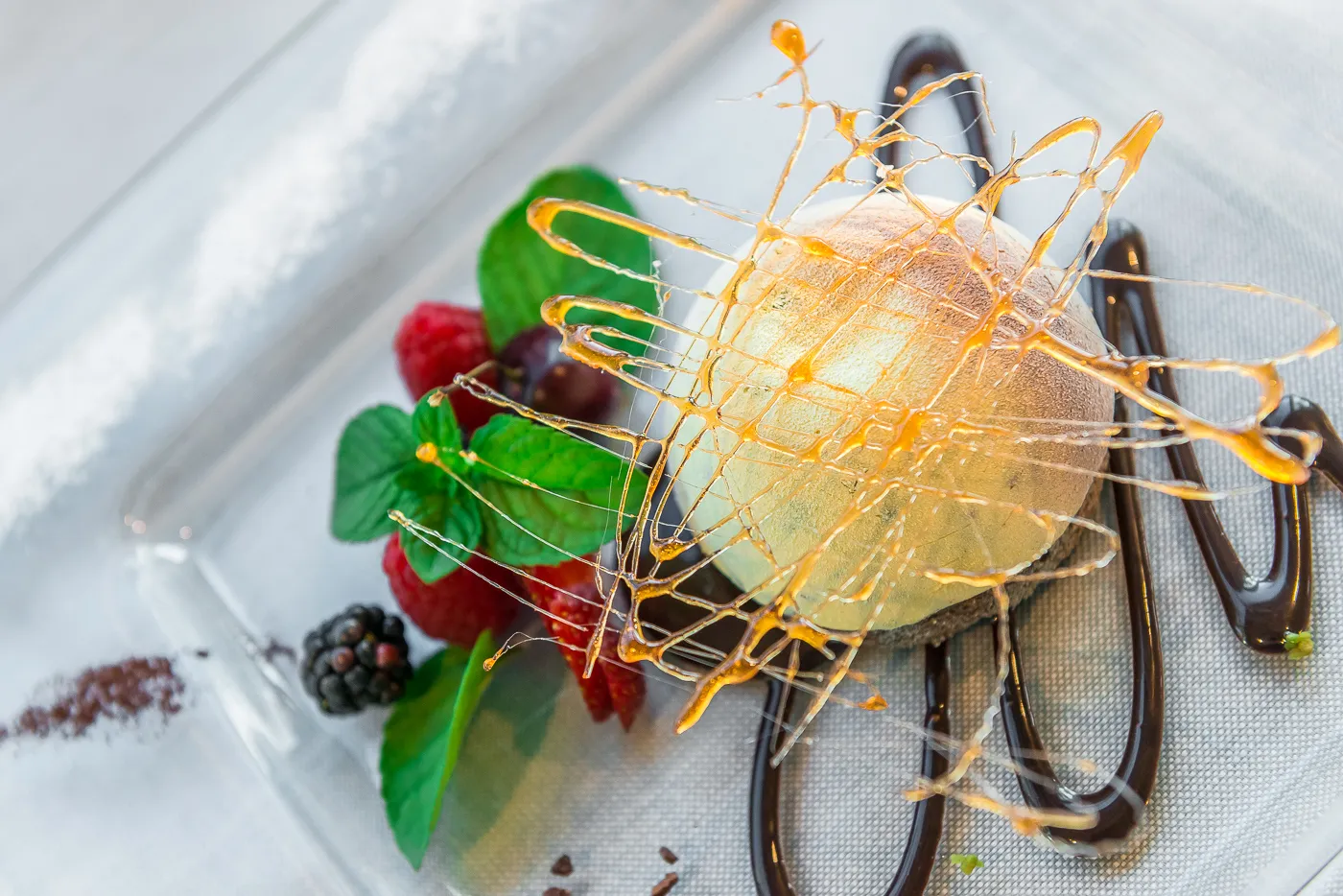Dessert con decorazione in caramello e frutti di bosco