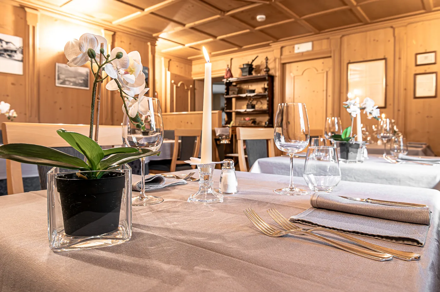 Tavolo apparecchiato con orchidea, candele e calici