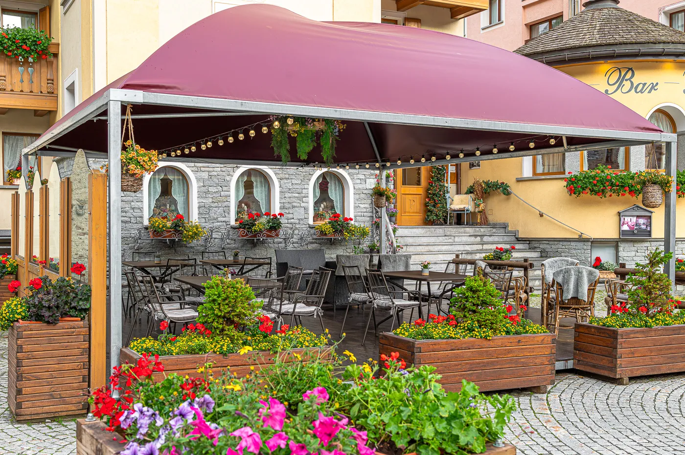 Il dehors fiorito dell’hotel con il gazebo e i gerani
