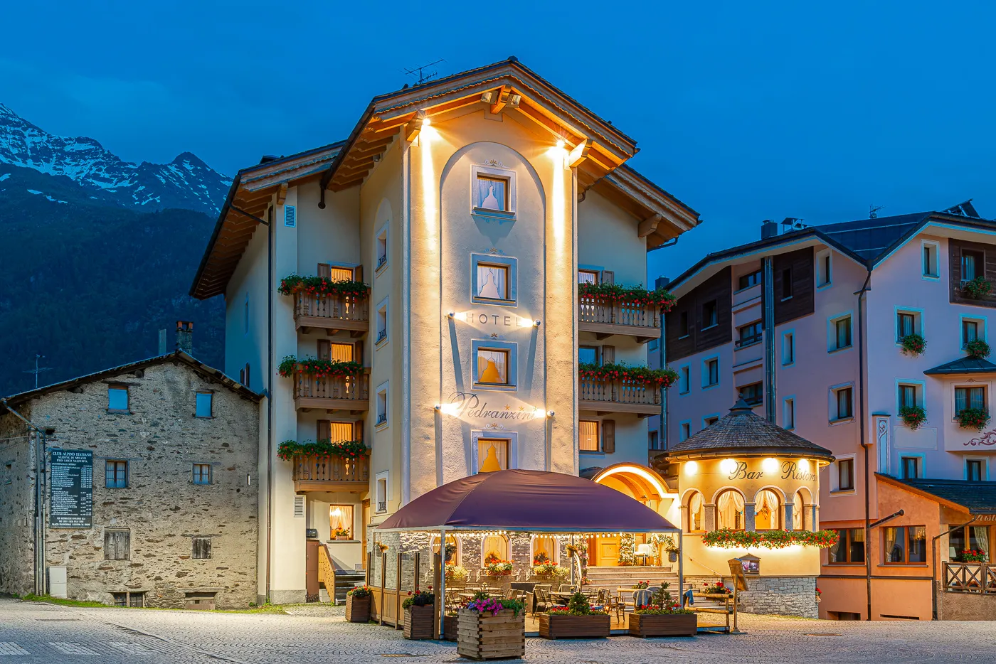 L’esterno dell’hotel in notturna, con le montagne sullo sfondo