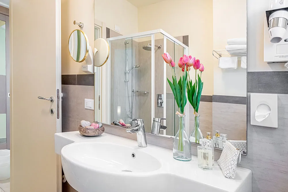 Bagno con lavabo, specchio e tulipani freschi