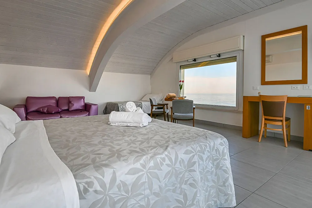 Junior suite con soffitto curvo e finestra sul mare