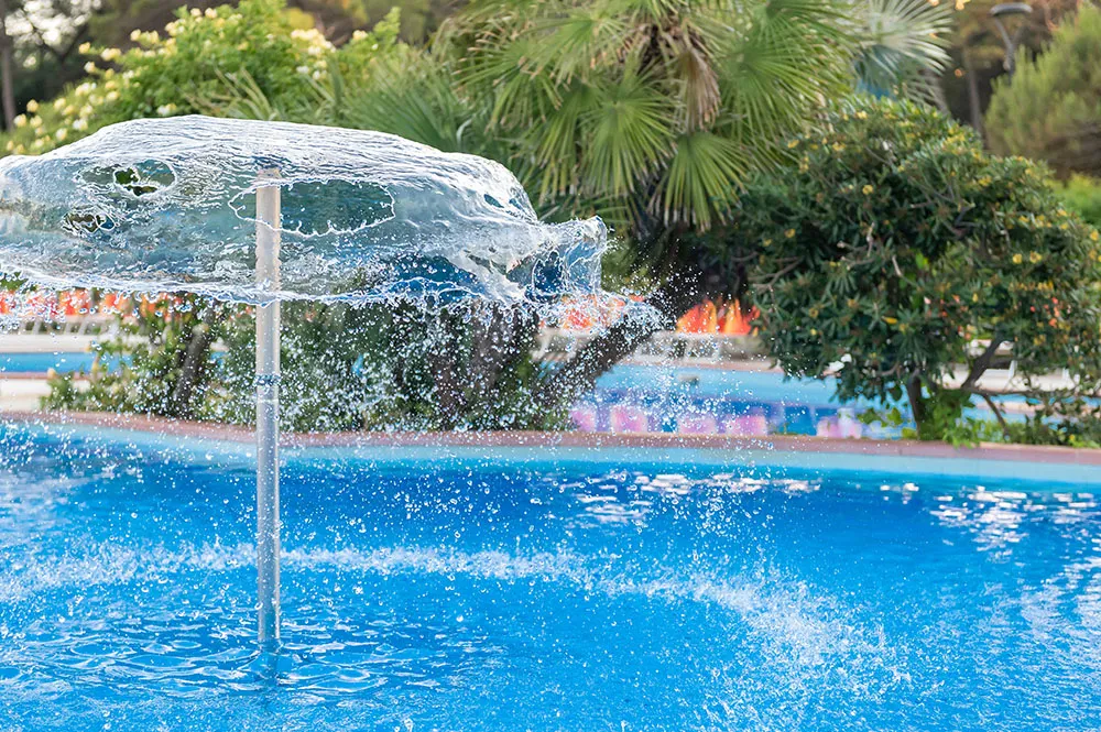 La piscina esterna con i giochi d’acqua e le palme