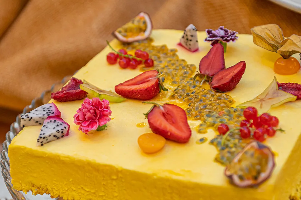 Fotografia food: dolce al piatto con fragole, ribes e frutto della passione